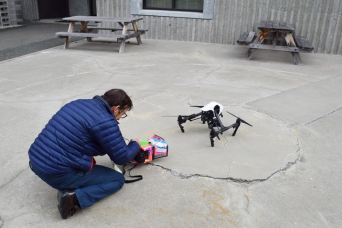 man with drone outside building