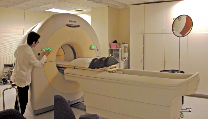 person working beside CT scanner