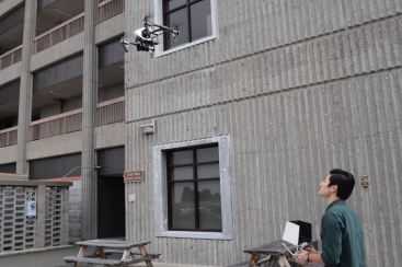 man with drone outside building