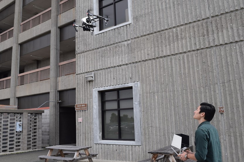 man flying drone outside buiilding